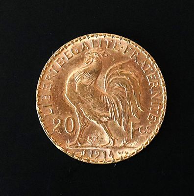 a gold coin with a rooster on it on a black surface