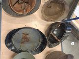 many different hats and pans sitting on a table