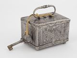une vieille boîte en argent sur laquelle repose une clé