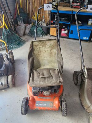 deux tondeuses à gazon qui sont rangées dans le garage
