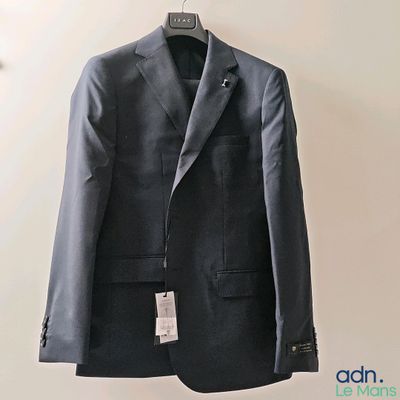 jacket hanging on a hanger on a wall with a tag on it