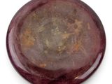 a close up of a red and brown stone on a white surface