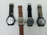 four different watches are lined up on a white surface