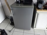 a small refrigerator with a coffee maker on top of it