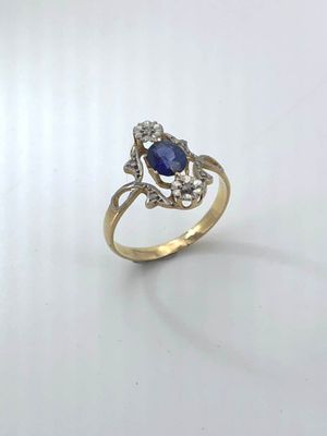 a close up of a gold ring with a sapphire and diamonds