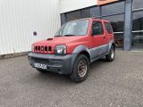 une photo d'une jeep rouge garée devant un immeuble