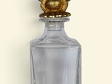 an image of a glass bottle with a gold flower on top