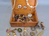 une boîte en bois remplie de bijoux variés, posée sur une table