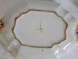 a white plate with a gold trim and a bird on it