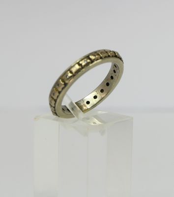 a gold ring with black dots on it sitting on a white surface