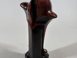 statue of a bird on a black base with a white background