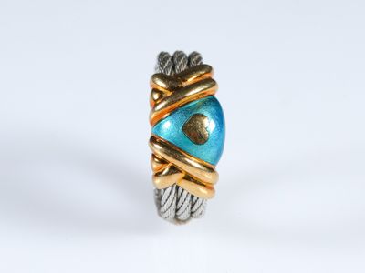 une image représentant une bague dorée et bleue ornée d'un cœur