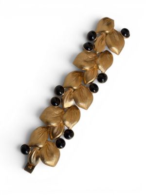 an image of a close up of a gold bracelet with black beads