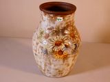 un vase orné d'un motif floral, posé sur une table