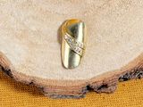 une bague en or sertie d'un diamant, posée sur un morceau de bois