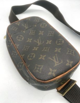 un gros plan d'un sac à bandoulière Louis Vuitton posé sur une surface blanche