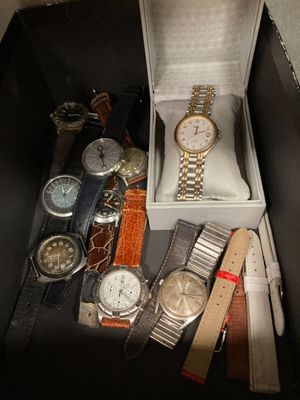 de nombreuses montres différentes dans une boîte posée sur la table