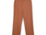 un gros plan sur le pantalon d'une personne suspendu à un cintre