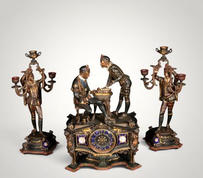 three bronze figurines of a man and a woman sitting on top of a table