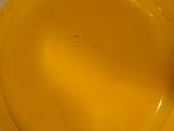 une assiette jaune posée sur une nappe blanche
