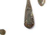 a silver spoon and a silver spoon on a white surface