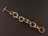 gros plan d'un bracelet en chaîne en or sur une surface noire
