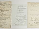several old papers are lined up on a white surface