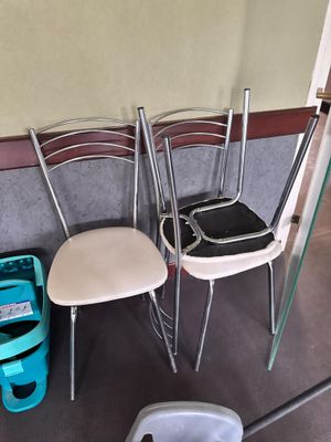 trois chaises et une poubelle dans un coin de la pièce
