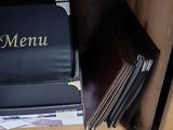 une boîte de menu noire posée sur une pile de livres