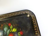 a black tray with a painting of fruit on it