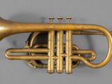 an old brass trumpet with two valves on a gray surface