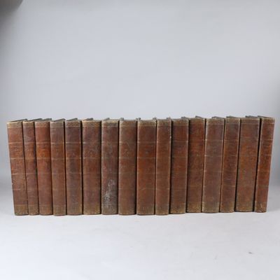 six vieux livres empilés sur une surface blanche