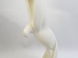 sculpture en céramique blanche représentant un oiseau posé sur un socle, sur fond blanc
