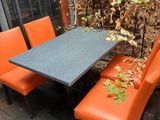 a table and four orange chairs on a wooden deck
