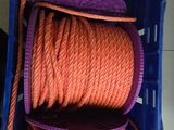 une corde orange dans une caisse bleue munie d'une poignée violette