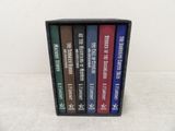 four books in a black case on a white surface