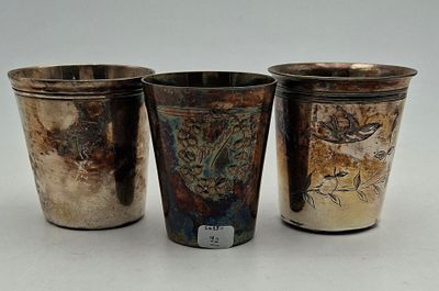 three silver cups sitting next to each other on top of a table