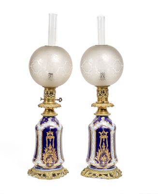 pair of blue and white lamps with gold trimmings on each of them