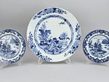 three blue and white plates and a plate stand on a white surface