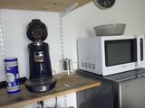 un micro-ondes et une cafetière posés sur une étagère dans une cuisine