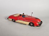 a red toy car with a man sitting in the driver ' s seat