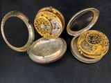 four different types of pocket watches on a black surface