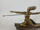 bronze statue of a woman holding a spear on a stack of books