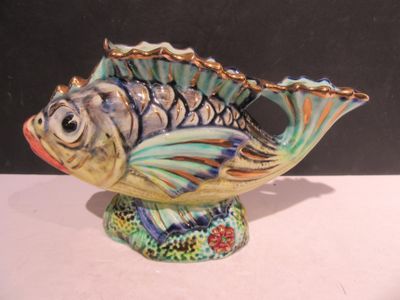 un vase en forme de poisson posé sur une table blanche