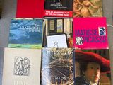 Plusieurs livres sont posés par terre, les uns à côté des autres.