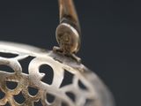 a close up of the handle of a silver tea pot
