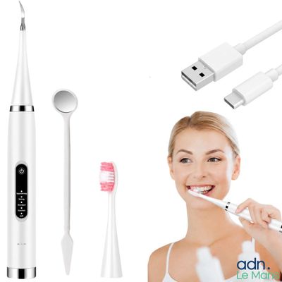une femme qui se brosse les dents avec une brosse à dents électrique