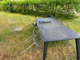 a table with chairs and a table top on the grass