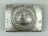 an old silver belt buckle with a crown on top of it