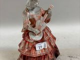 une figurine représentant une femme jouant de la guitare